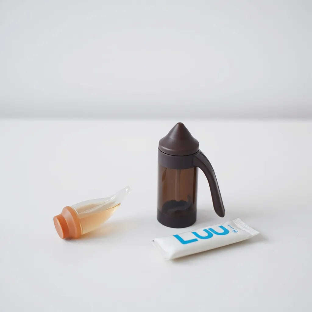 Penis pump sex toy and water-based lube set on a clean tabletop in soft studio light
